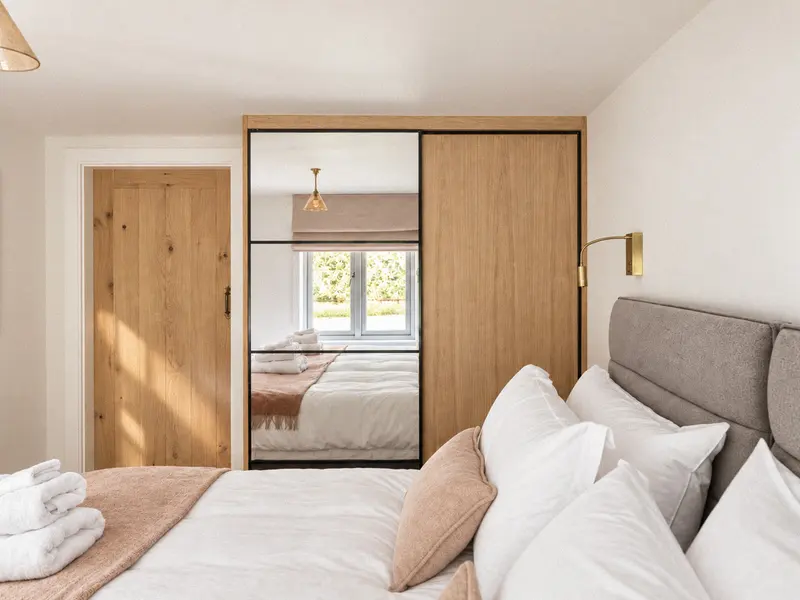 Double bedroom with a mirrored oak wardrobe and folded towels