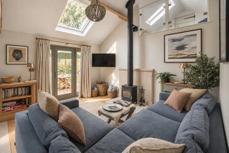 Blue sofa beside the wood-burning stove and garden doors