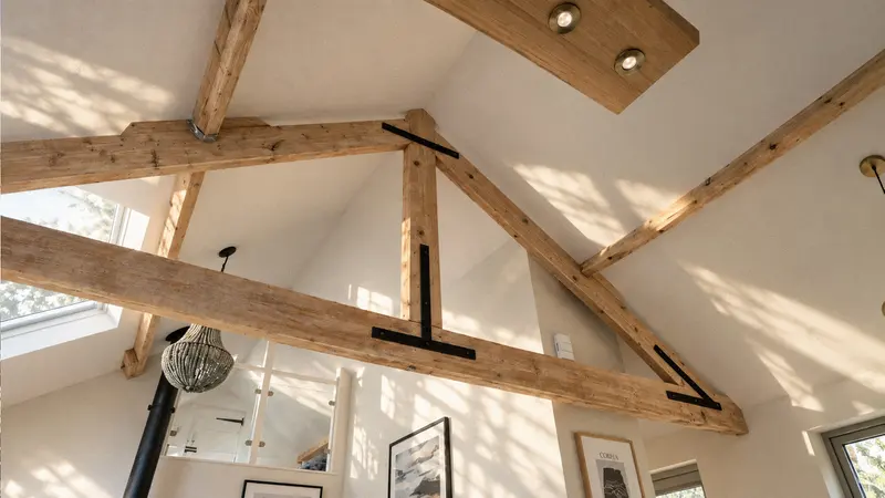 Exposed timber roof trusses beneath the whitewashed ceiling